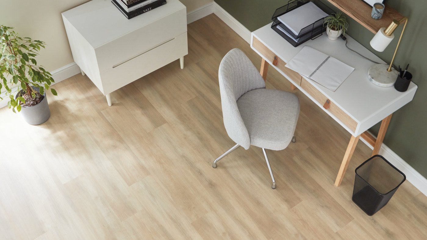 light wood flooring in a specious home office with chair and desk.